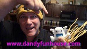 neil dandy holding yeti toy and pointing to the dandy fun house website address