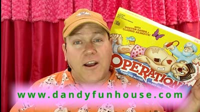 neil dandy holding game box with dandy fun house website address showing