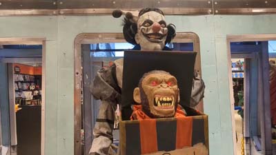 evil clown animatronic with a gorilla head sticking out of a box
