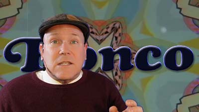 neil dandy with a 60s kaleidoscope background with an early version of the ronco logo