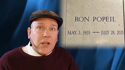 neil dandy with a picture of ron popeil's headstone