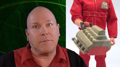 neil dandy with six million dollar man action figure lifting an engine block